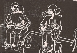 two friends regard each other, one is his motorized chair, one in their scooter. They appear to be sharing a meal, or perhaps a joke.